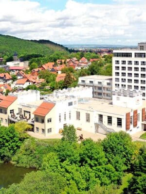 Flugansicht des Burghotels im Sommer mit Burg-See, viel Grün und Blick auf die Umgebung von Wernigerode