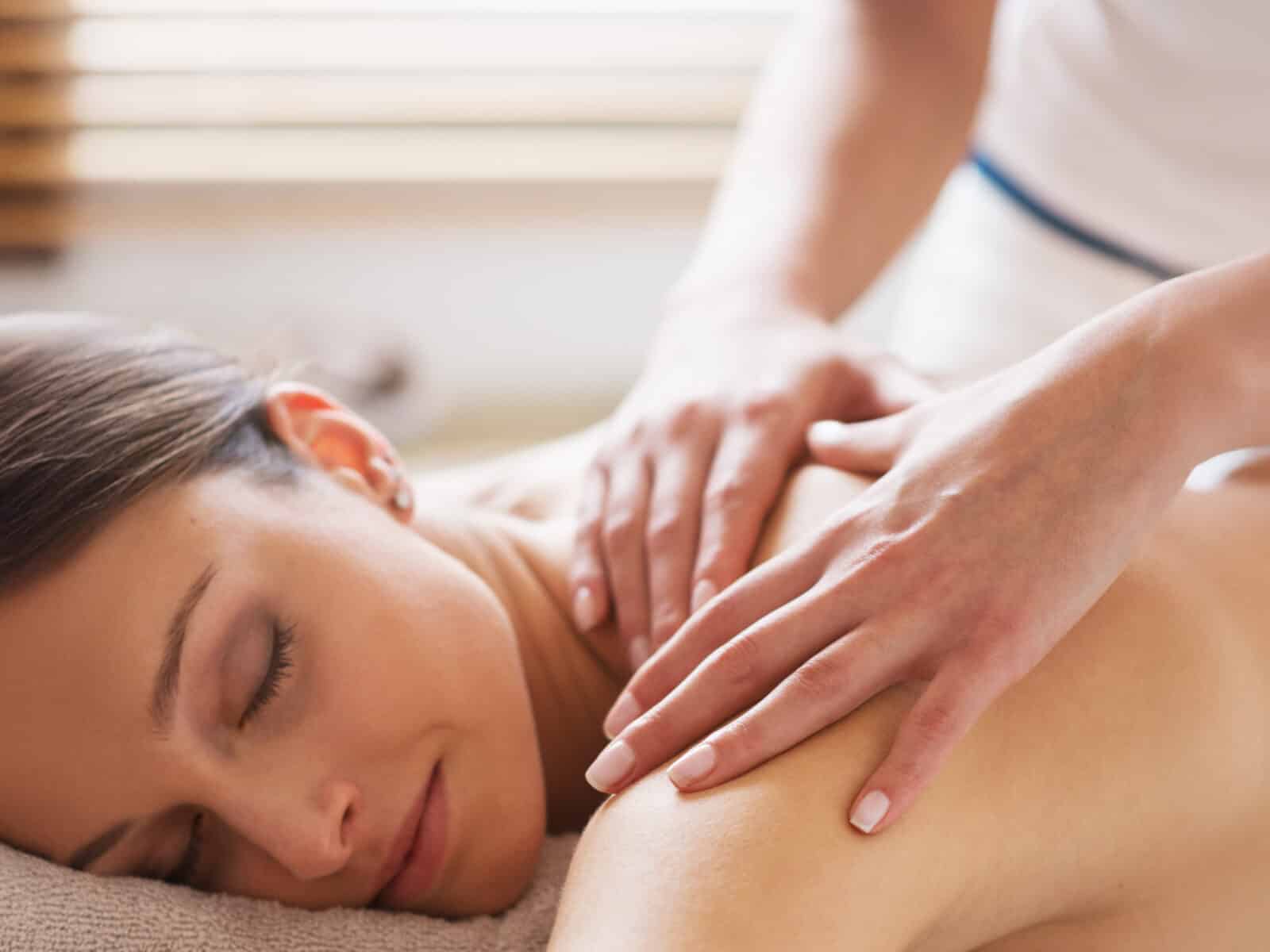 Entspannte Frau bei einer wohltuenden Rückenmassage im Wellnessbereich des Hasseröder Burghotels Wernigerode