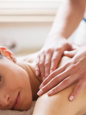 Entspannte Frau bei einer wohltuenden Rückenmassage im Wellnessbereich des Hasseröder Burghotels Wernigerode