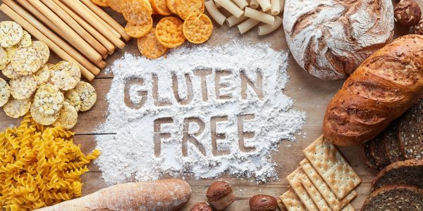 Gluten free food. Various pasta, bread and snacks on wooden background from top view