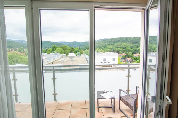 Balkon des Familienzimmers Comfort mit Aussicht auf die Harzer Wälder; die Zimmer sind je nach Lage auch mit Stadtblick verfügbar