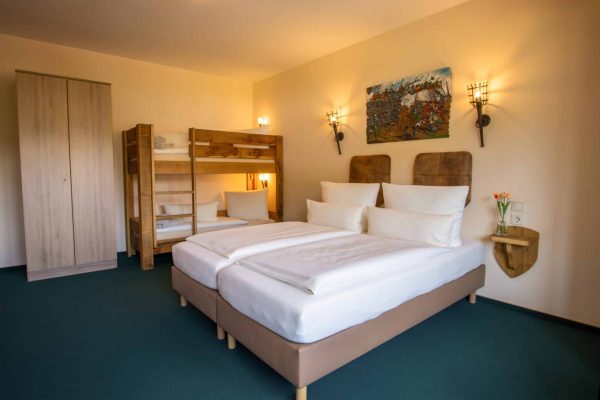Schlafzimmer mit Doppelbett und Stockbett im Familienapartment für bis zu sechs Personen im Hasseröder Burghotel Wernigerode