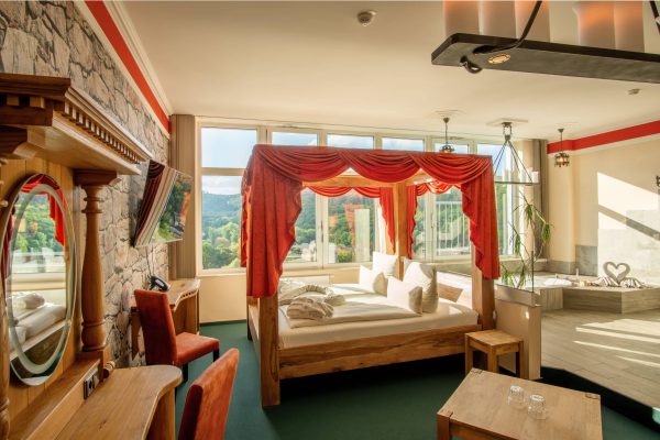 Honeymoon Suite mit Himmelbett, Wellnessbadewanne, Infrarotsauna und Panoramablick auf die Harzer Wälder im Hasseröder Burghotel Wernigerode